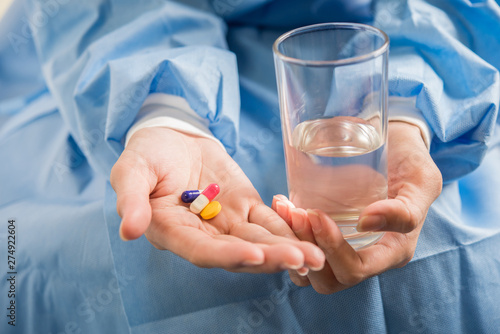 Woman's hand pours the medicine pills out of the bottle