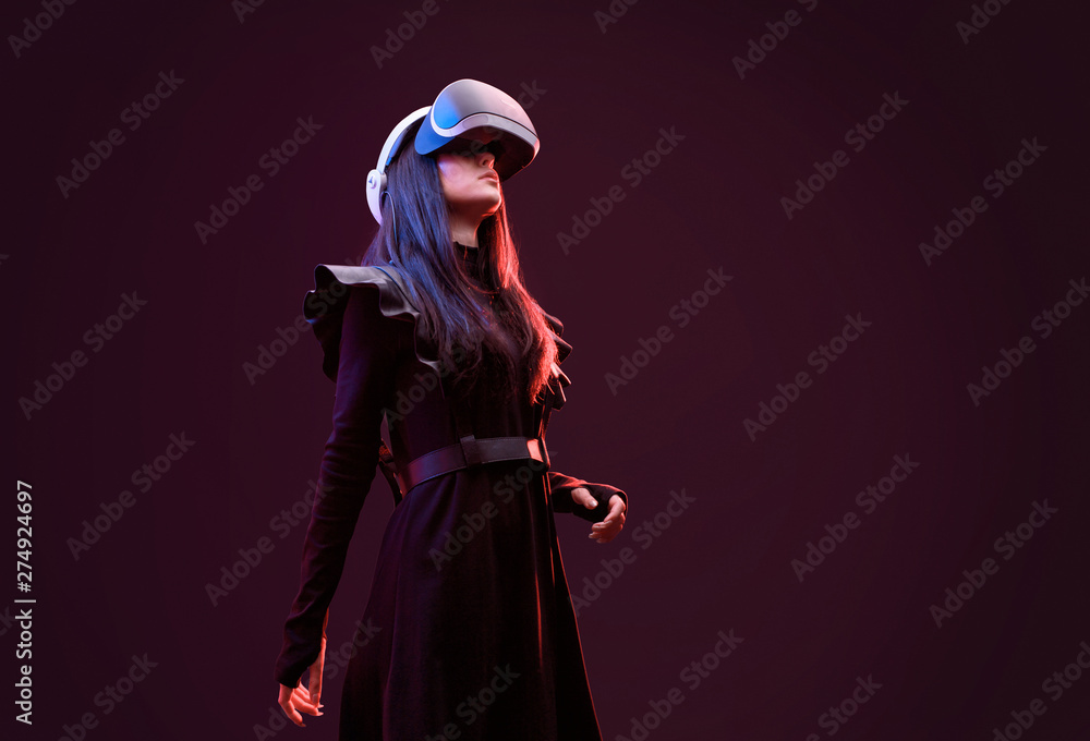 Beautiful woman in futuristic dress over dark background. Girl in