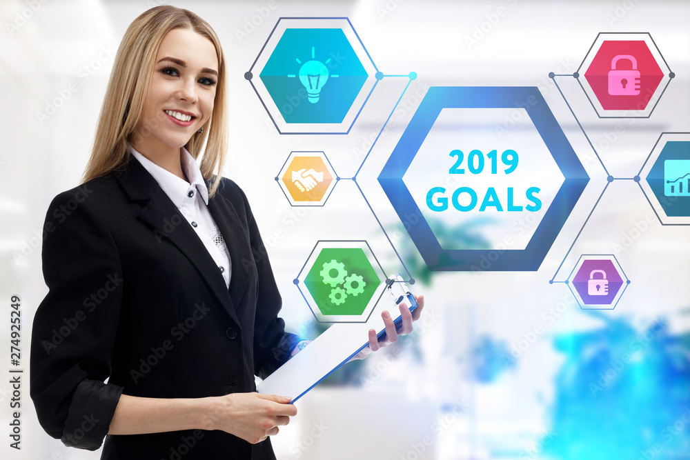 The concept of business, technology, the Internet and the network. A young entrepreneur working on a virtual screen of the future and sees the inscription: 2019 goals The concept of business, technology, the Internet and the network. A young entrepreneur working on a virtual screen of the future and sees the inscription: 2019 goals