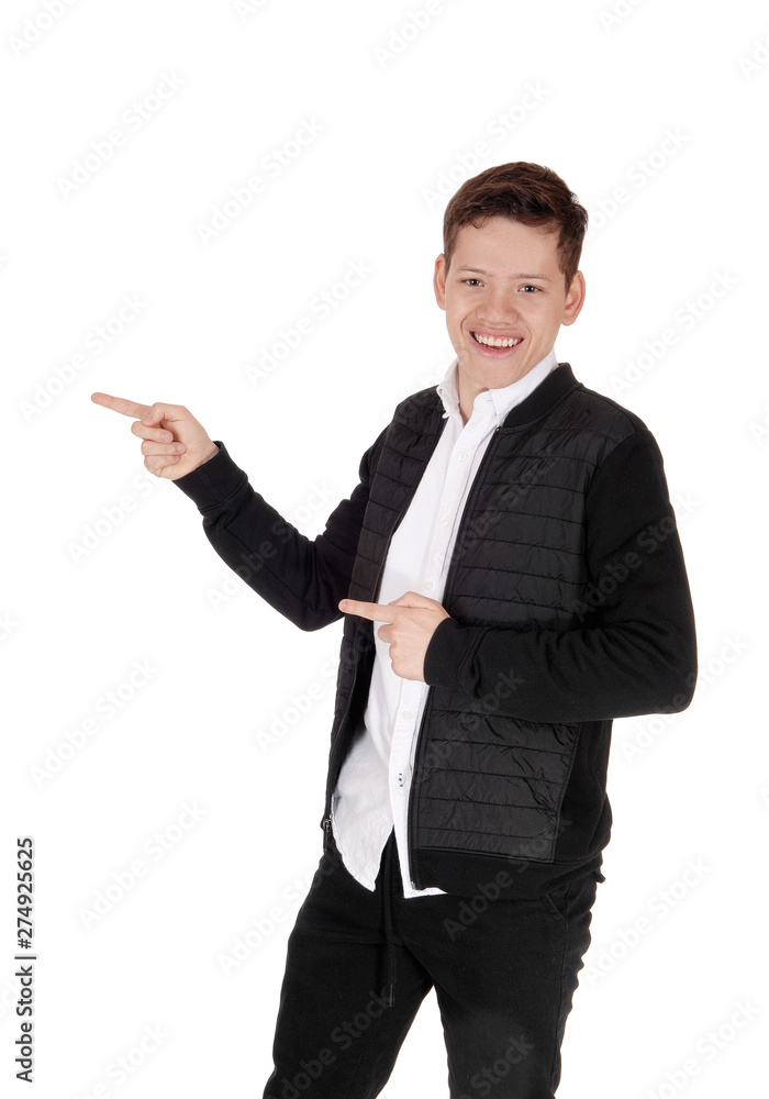 Smiling young teen boy standing, pointing with his fingers Smiling young teen boy standing, pointing with his fingers