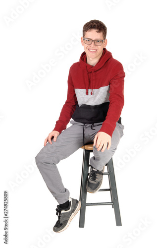 Smiling teen boy sitting on a chair