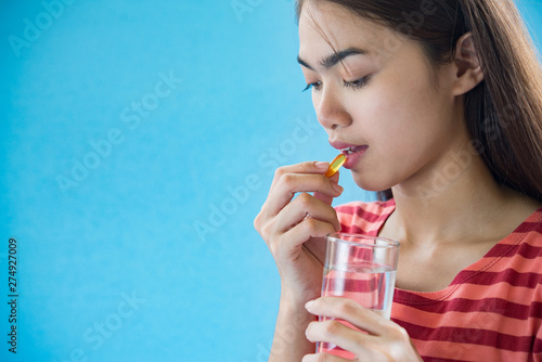 Young woman taking medicine pill after doctor order