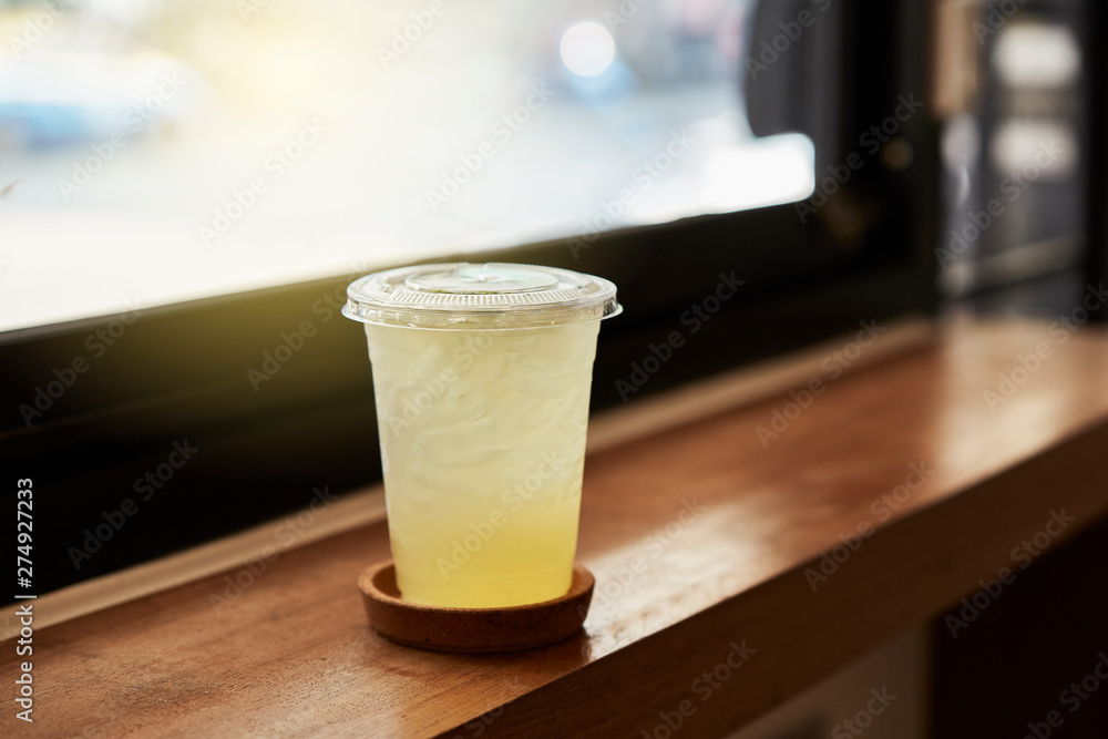 Plastic glass of lemon tea for take a way on table in cafeteria. Plastic glass of lemon tea for take a way on table in cafeteria.
