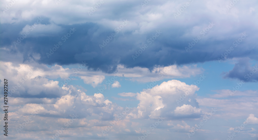White curly clouds in a blue sky. Sky background White curly clouds in a blue sky. Sky background