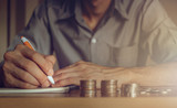 Businessman taking notes and stack of coins to create an account, Business ,save money concept.