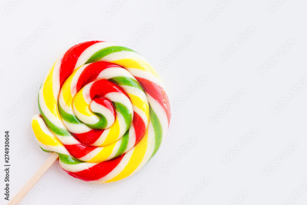 Multicolored round lollipop on a white background. Rainbow background of sweets. Lollipops with stripes. Round sweet candies. Copy space