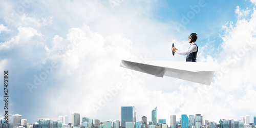Wallpaper Mural Aviator driving paper plane above business center Torontodigital.ca