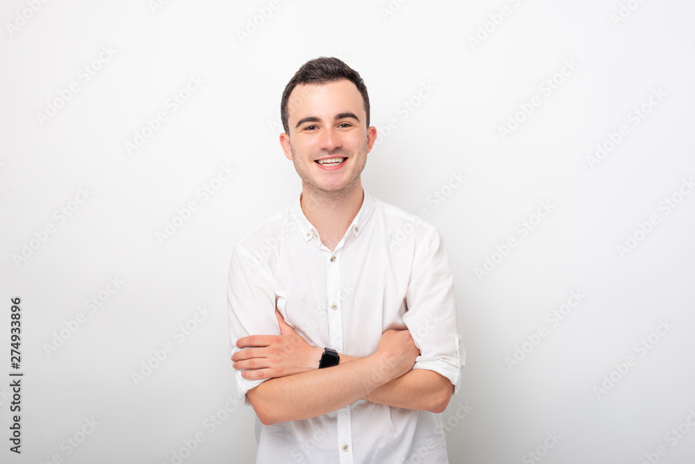 Portrait of a young smiling man with crossed arms on white background. Portrait of a young smiling man with crossed arms on white background.