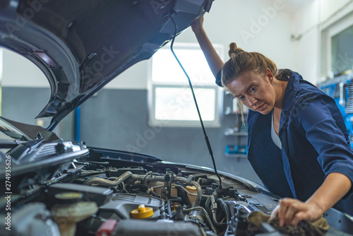 Female Auto mechanic working in garage. Repair service. Woman with dirty hands fixing the car. Getting her car back on the road. Mechanic working in his workshop