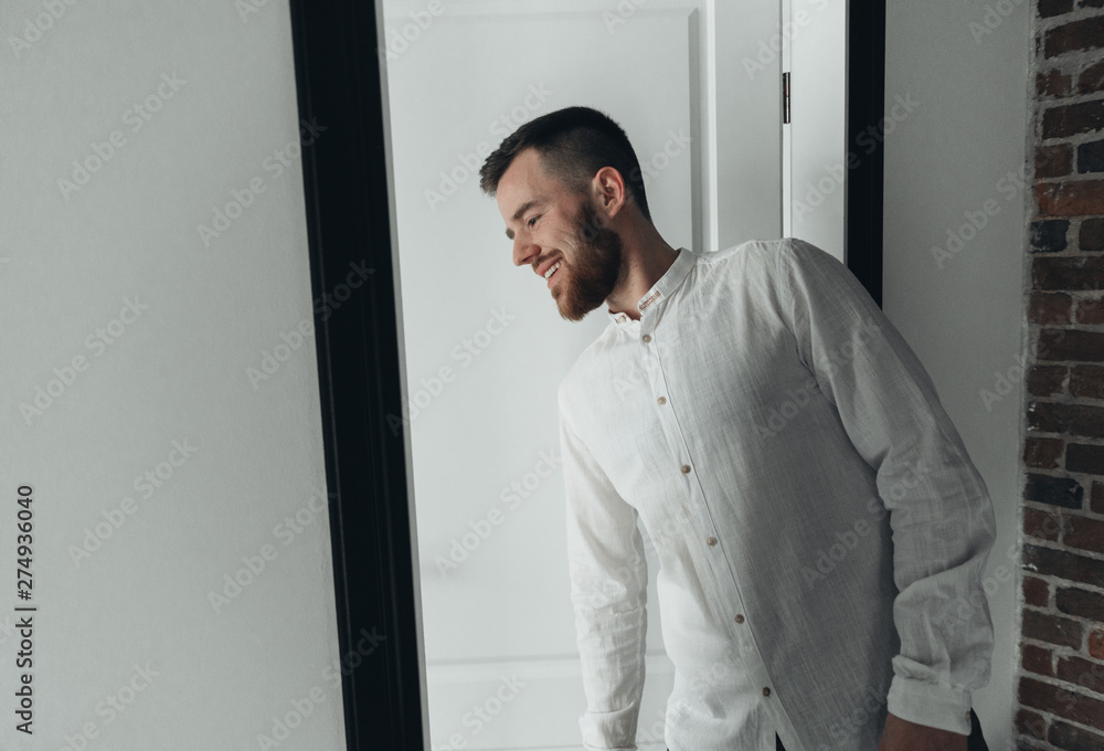 Girl is gathering for a walk. Husband is waiting for wife. Female is preparing for a date. Dressing a newly-married couple. Man standing by the door Girl is gathering for a walk. Husband is waiting for wife. Female is preparing for a date. Dressing a newly-married couple. Man standing by the door