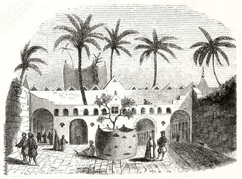 Ancient oriental courtyard with arabian people inside and high palms. Typical architecture in Gadames Libya. By unidentified author publ. on Magasin Pittoresque Paris-1848 photo