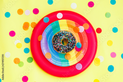 Celebración con donut de chocolate, confeti y virutas de colores photo