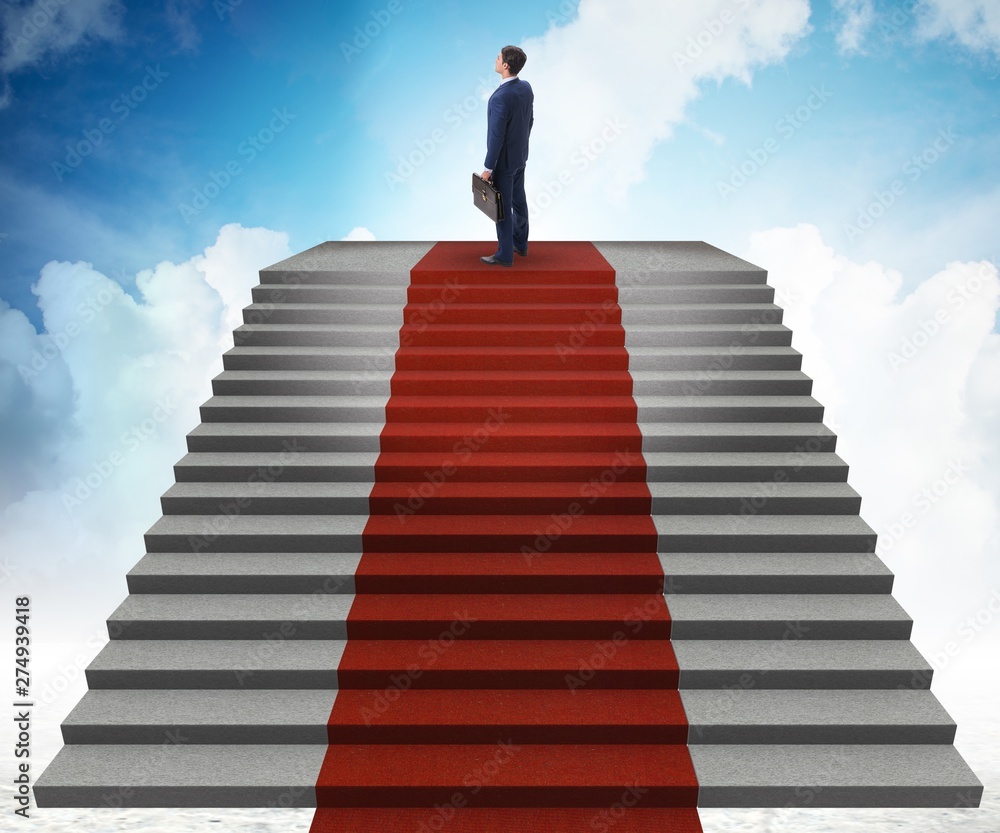 Young businessman climbing stairs and red carpet into sky