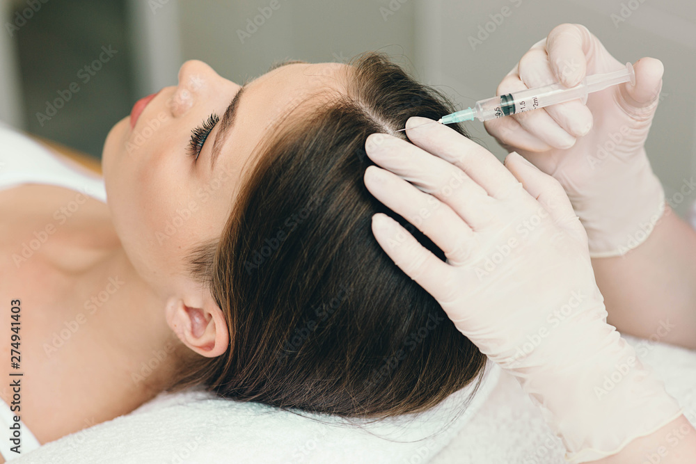 Fototapeta premium treatment of hair loss, injection for hair growth. Injected in woman's head, hair mesotherapy