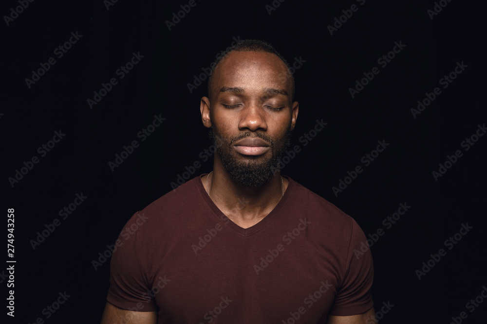 Close up portrait of young man isolated on black studio background. Photoshot of real emotions of male model with closed eyes. Thoughtful. Facial expression, human nature and emotions concept.