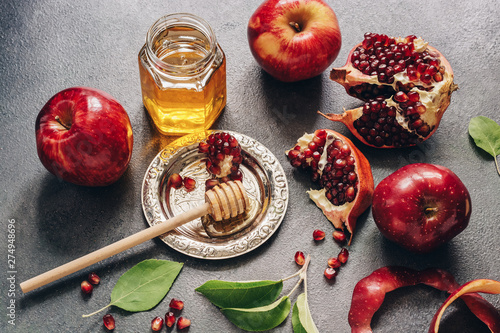 Apples, pomegranate and honey on a dark rustic background. New Year - Rosh Hashanah. Traditional Jewish food. photo
