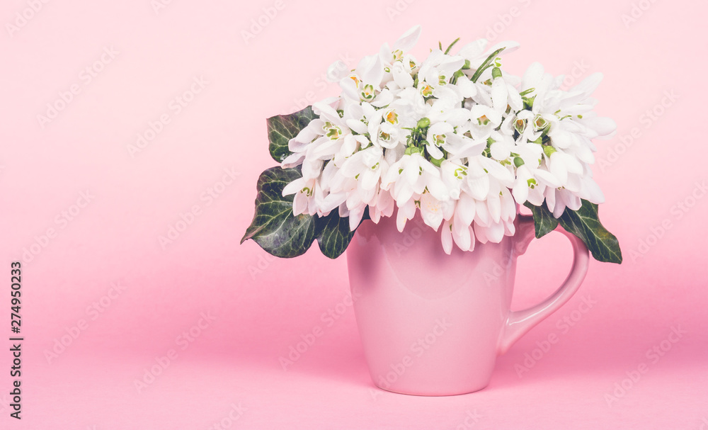 Pink mug on pink background. Pink mug with white flowers. Copy space
