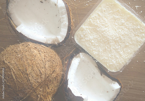 Coco seco aberto junto com doce de coco em fundo amadeirado photo
