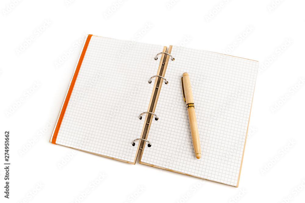 The handle in a wooden case with a cap lies on an empty sheet of an open notebook with a wooden cover. Isolated on white background.