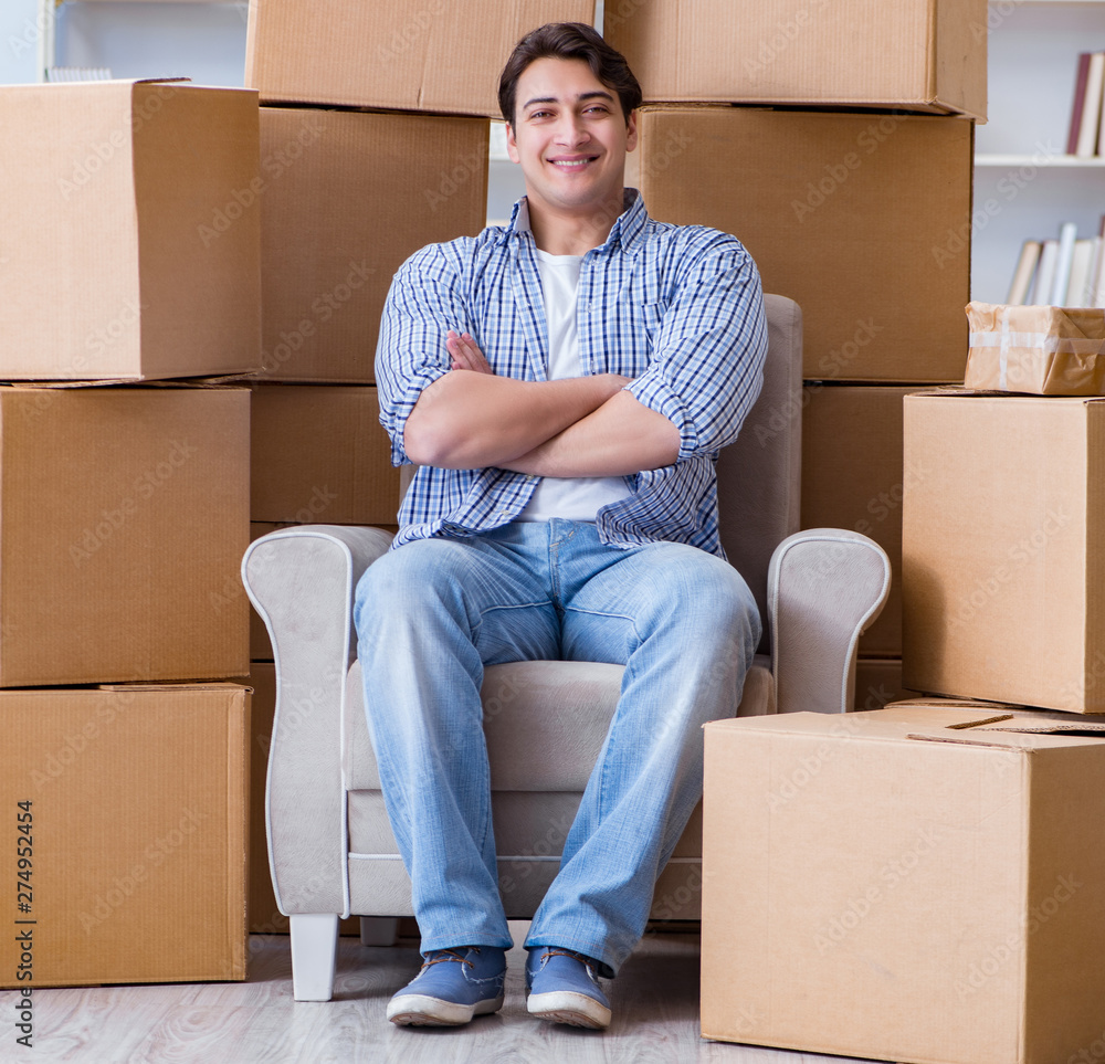 Young man moving in to new house with boxes Young man moving in to new house with boxes