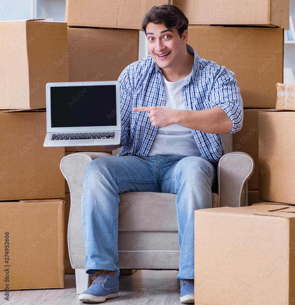 Young man moving in to new house with boxes Young man moving in to new house with boxes