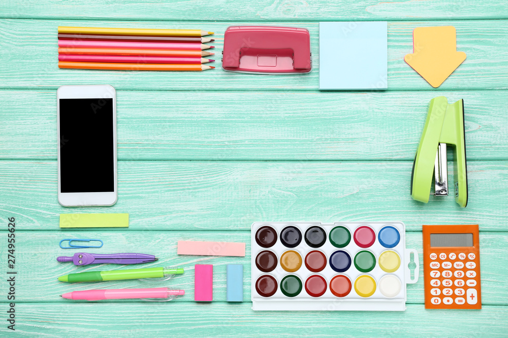 School supplies with smartphone on mint wooden table School supplies with smartphone on mint wooden table