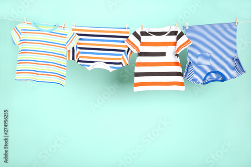 Baby clothes hanging on blue background