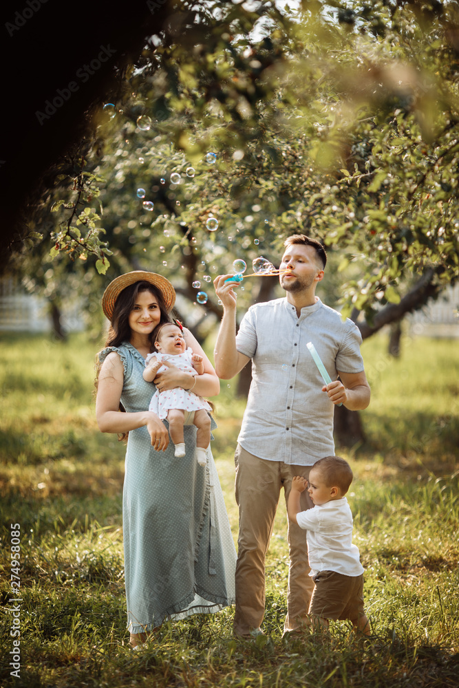 Fototapeta premium Happy family in the green garden at summer