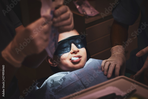 Dental operation is finished and little kid in protective googles is happy about it.