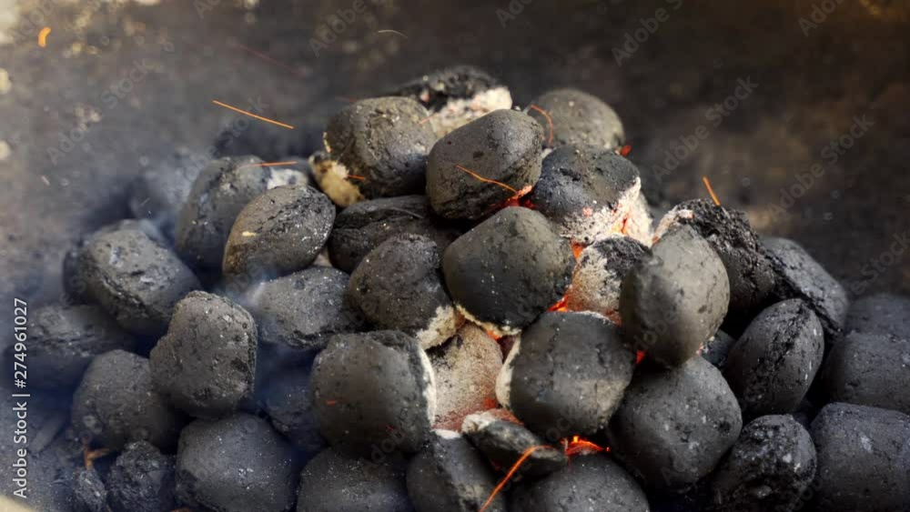 Closeup of glowing coal in metal grill on summer day in garden Closeup of glowing coal in metal grill on summer day in garden