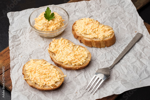 Grated cheese bruschetta with garlic on crumpled paper background. Cooking. Close up