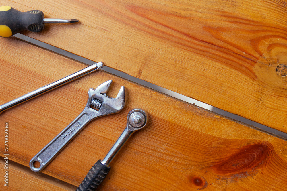 A various assortment of tools is laying on a wooden surface A various assortment of tools is laying on a wooden surface
