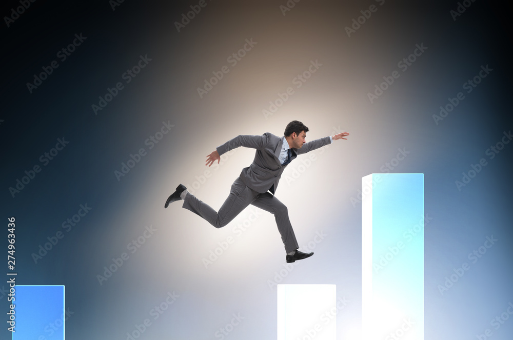 Young businessman in business concept with bar charts Young businessman in business concept with bar charts