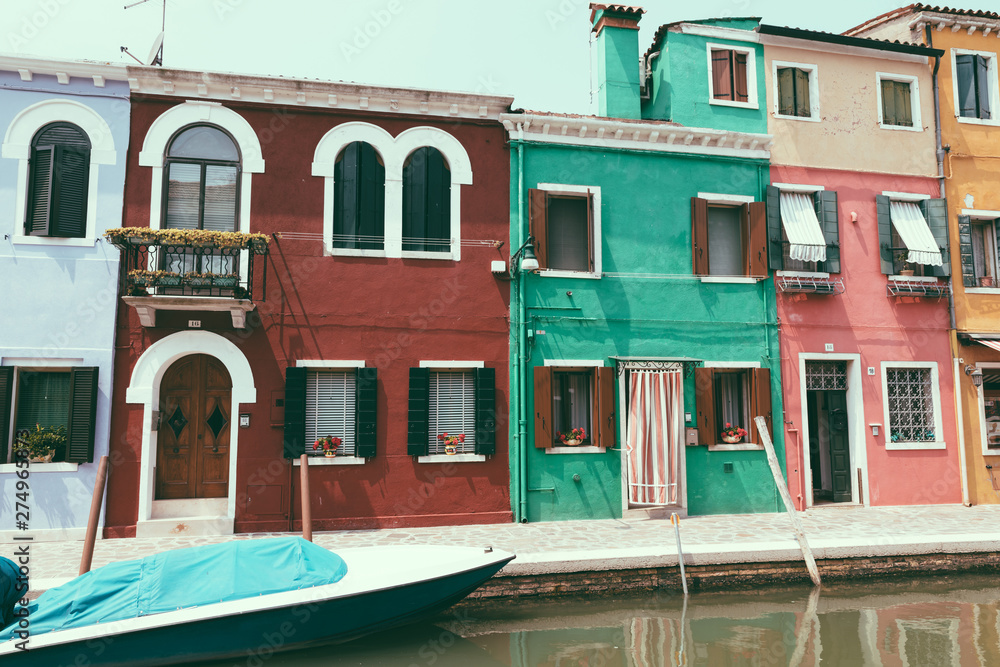 Panoramic view of coloured homes and water canal with boats in Burano Panoramic view of coloured homes and water canal with boats in Burano