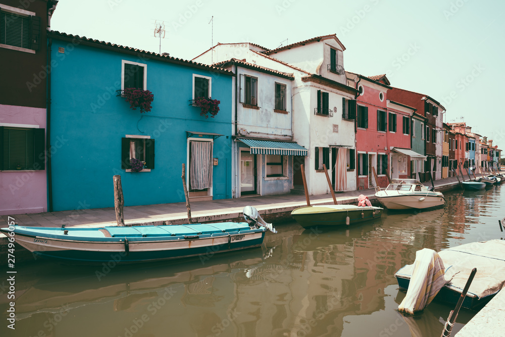 Panoramic view of coloured homes and water canal with boats in Burano