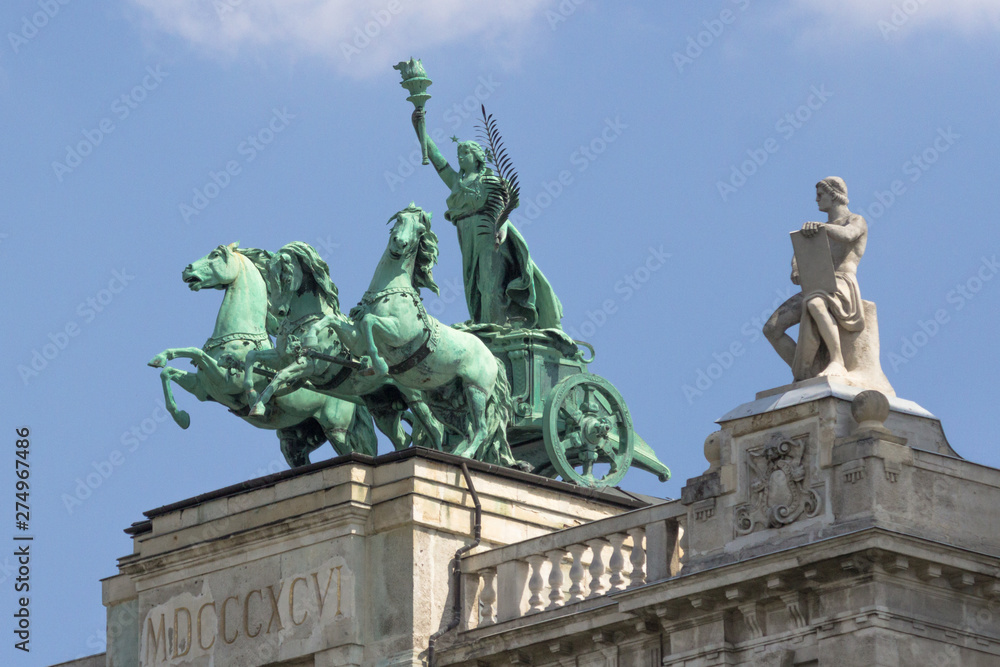 Parliament Building in Budapest. State institution in Hungary. Exterior of a historic building. Coats of arms on the wall. Statue with horses on the roof of the parliament. European architecture.