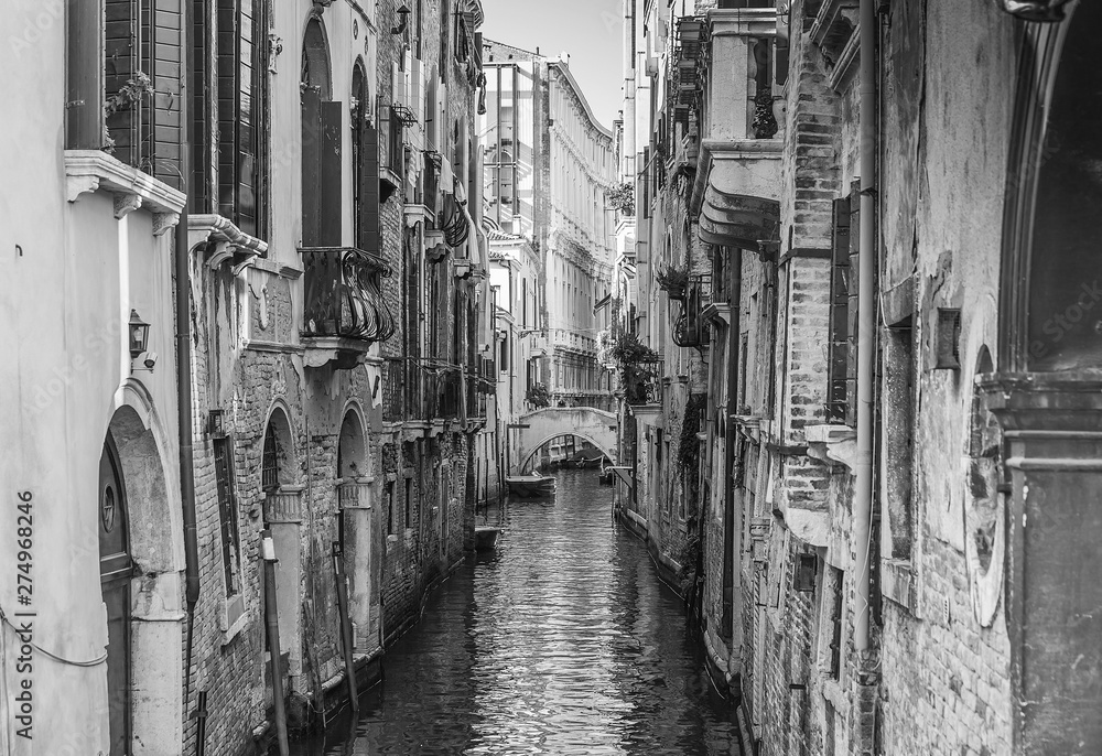 Fototapeta premium Narrow canal among old colorful brick houses in Venice, Italy.