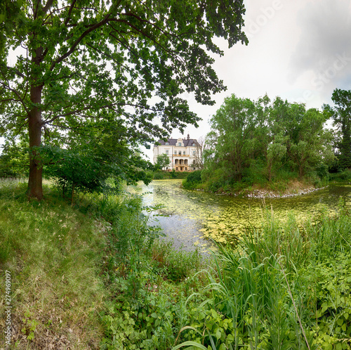 WROCLAW, POLAND - JUNE 21, 2019: Palace in Biskupice Podgorne near Wroclaw, Poland. Cloudy sky on the last day of spring. photo