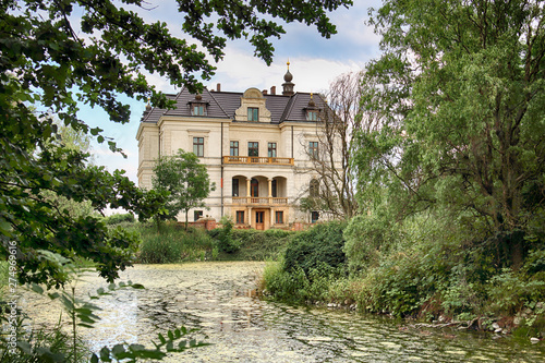 WROCLAW, POLAND - JUNE 21, 2019: Palace in Biskupice Podgorne near Wroclaw, Poland. Cloudy sky on the last day of spring. photo