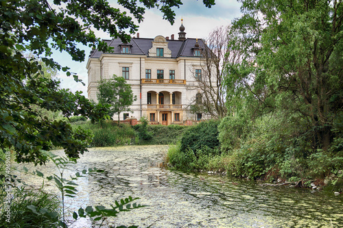 WROCLAW, POLAND - JUNE 21, 2019: Palace in Biskupice Podgorne near Wroclaw, Poland. Cloudy sky on the last day of spring. photo