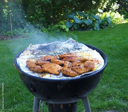 Heißes Fleisch auf Grill im sommerlichen Garten