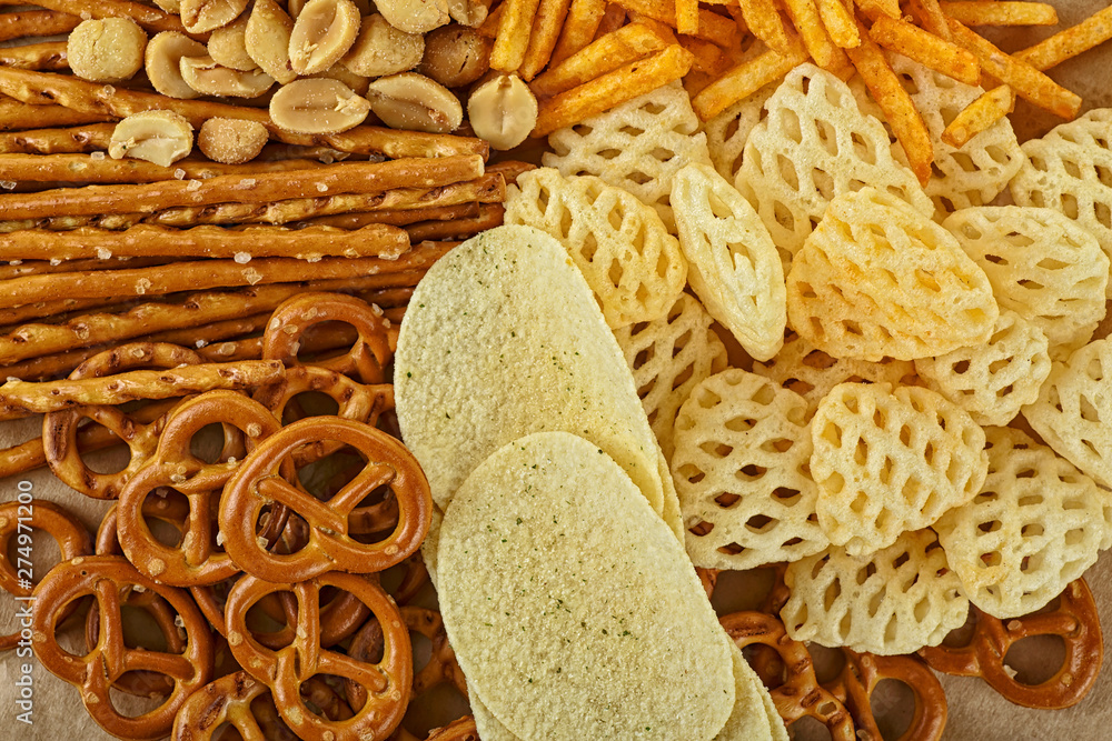 Salty snacks. Pretzels, potato chips, crackers on brown paper