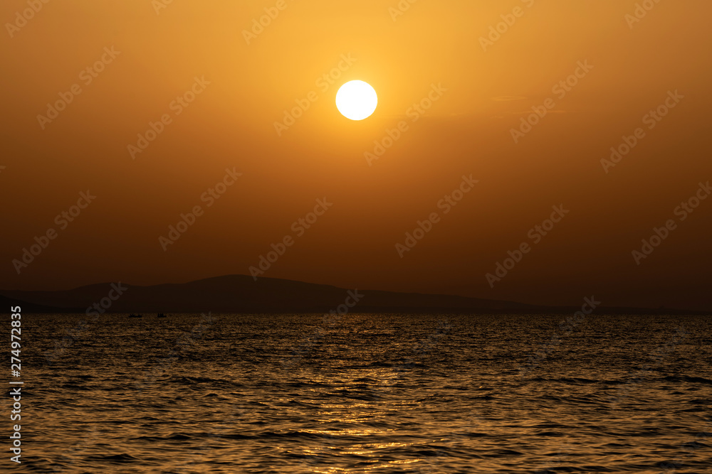 Bright sunset with yellow sun the sea surface