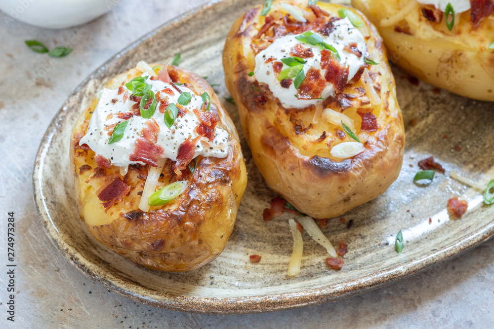 Baked loaded potato with bacon, cheese, sour cream and onion Baked loaded potato with bacon, cheese, sour cream and onion