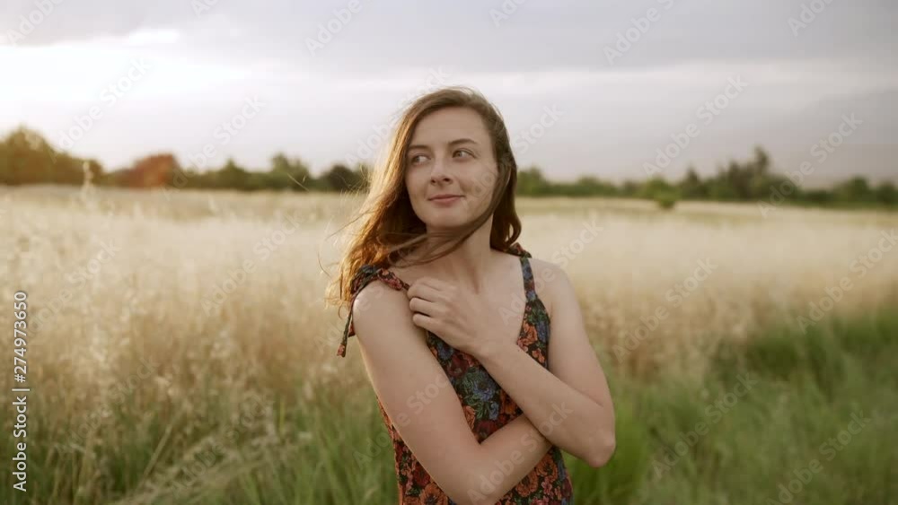 Woman looking at camera and smiling at fields with high grass. Slowmotion Woman looking at camera and smiling at fields with high grass. Slowmotion