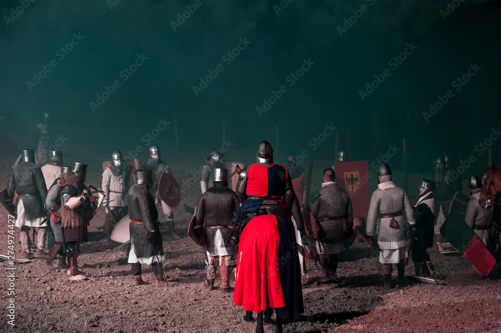 Unidentified participants during a historical reenactment. Medieval warriors standing on the battlefield after the fight.
