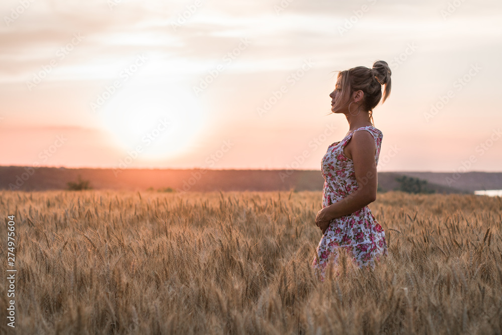 young seductive rural blond hair woman in dress on the yellow wheat field on the sunset, lake on the background young seductive rural blond hair woman in dress on the yellow wheat field on the sunset, lake on the background