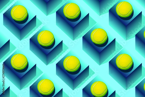 Creative composition made with tennis ball on blue geometric background. Sport tennis pattern. Flat lay.