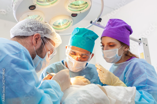 Baldness treatment. Hair transplant. Surgeons in the operating room carry out hair transplant surgery. Surgical technique that moves hair follicles from a part of the head.