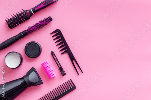 Fototapeta Naklejka Na Ścianę i Meble -  professional accessories of hairdresser with combs on work desk pink background top view copyspace